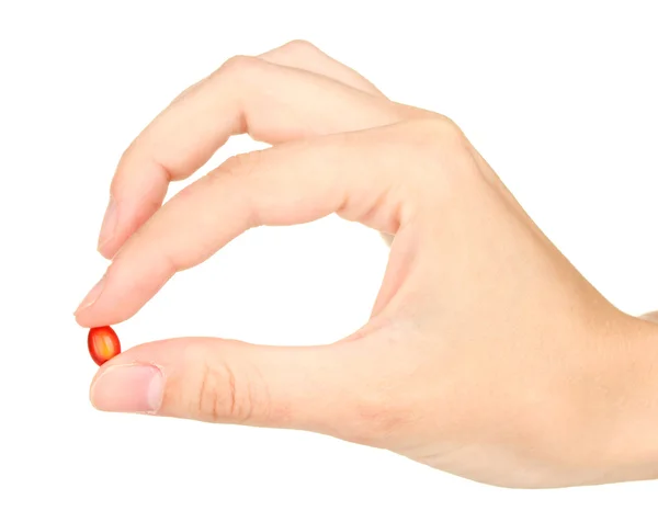 Woman's hand holding a red pill on white background close-up Stock Image