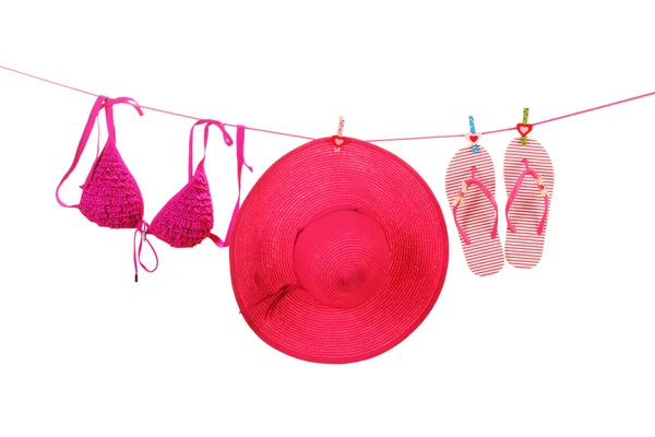Women's bra swimsuit, hat and flip-flops hanging on a rope on white background — Stock Photo, Image