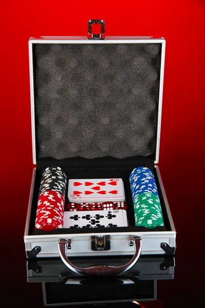 Набір покеру в металевому футлярі на яскраво-червоному тлі — стокове фото