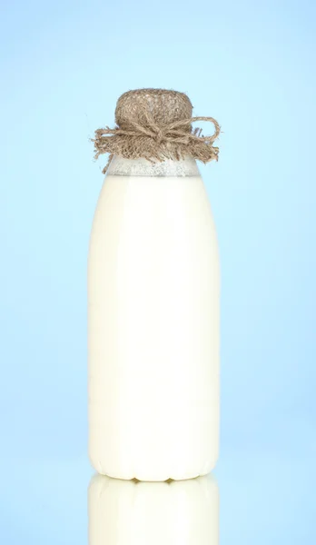 Flaska mjölk på blå bakgrund närbild — Stockfoto
