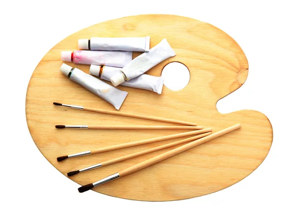 Tavolozza d'arte in legno, tubi con vernice e pennelli isolati su bianco — Foto Stock
