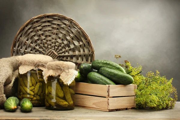 Concombres frais dans une boîte en bois, cornichons et aneth, sur fond gris — Photo