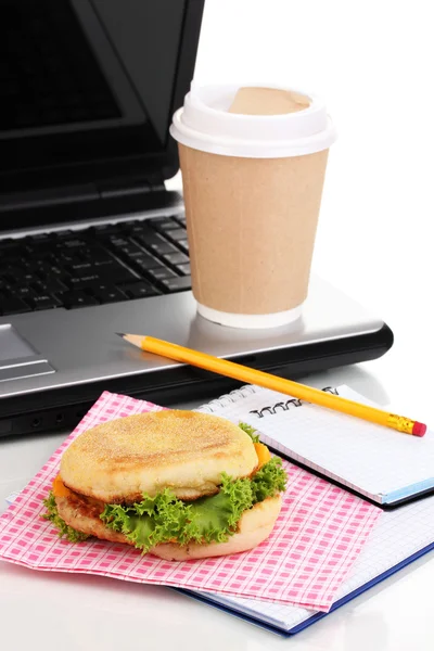 Äta på arbetsplats nära laptop — Stockfoto