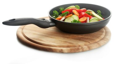 Frying pan with vegetables on white clipart