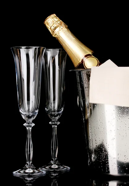 Botella de champán en cubo con hielo y vasos aislados en negro —  Fotos de Stock