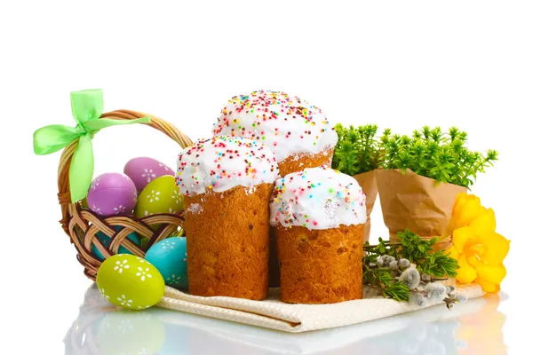 Красиві великодні торти, різнокольорові яйця в кошику і гілочки вівчарки ізольовані на білому — стокове фото