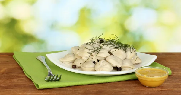 Heerlijk gekookt dumplings in de schotel op helder groene achtergrond — Stockfoto
