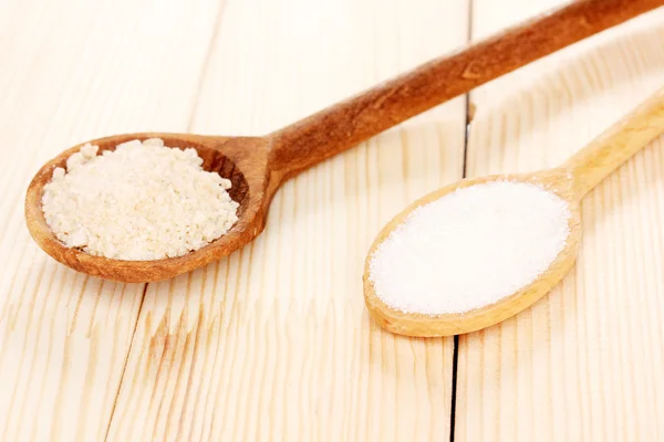 Weißer und brauner Zucker in Löffeln auf Holzgrund — Stockfoto