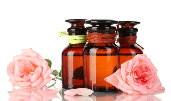 Bottles of oil and roses isolated on white — Stock Photo, Image