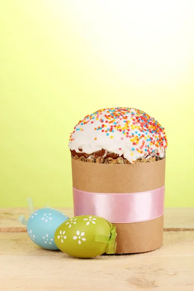Vackra påsk kaka med ägg på träbord på grön bakgrund — Stockfoto