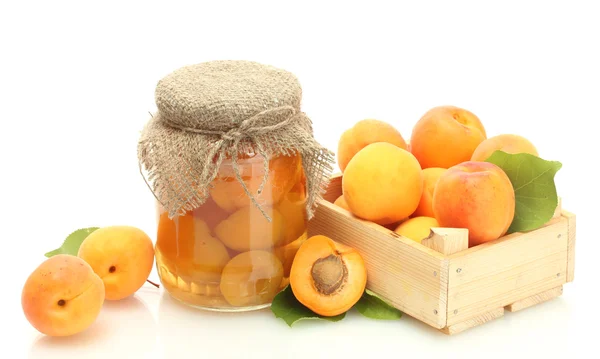 Konserverade aprikoser i en burk och färska aprikoser i trälåda isolerad på vit — Stockfoto