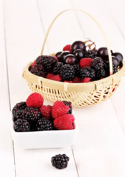 Ripe raspberries and brambles on wooden table — Stock Photo, Image