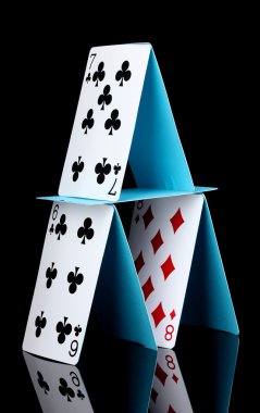 Card house isolated on black clipart