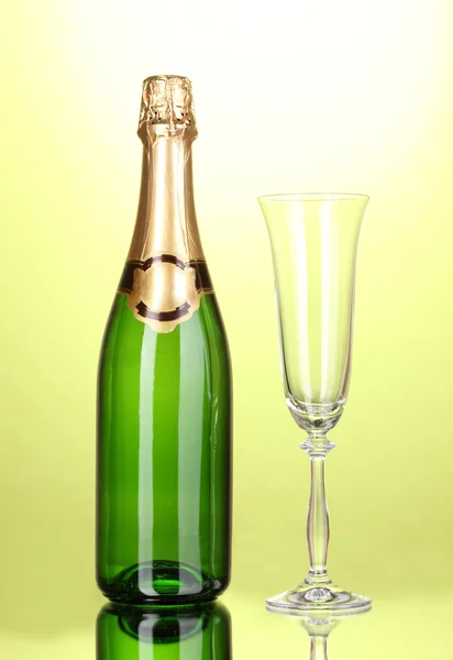 Бутылка шампанского и кубок на зеленом фоне — стоковое фото