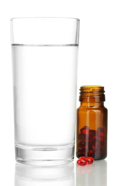 Un vaso de agua y pastillas aisladas en un primer plano blanco —  Fotos de Stock