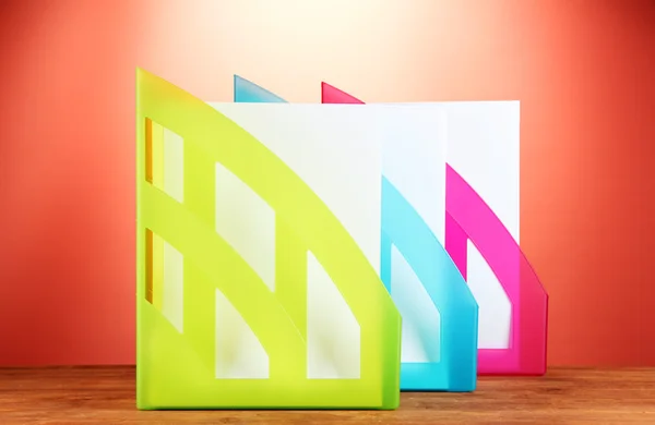 Colorful trays for papers on red background close-up — Stock Photo, Image