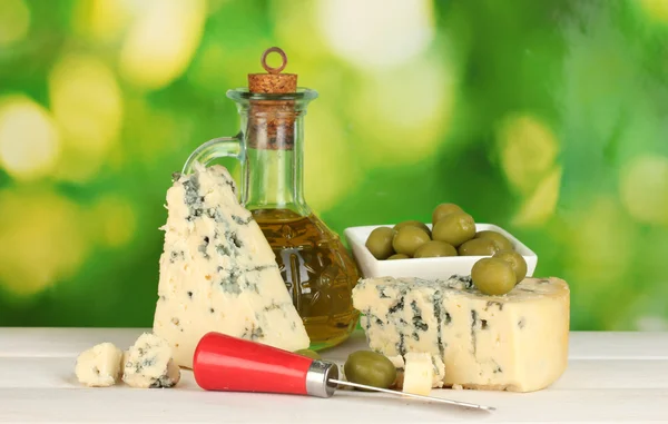 Composizione di formaggio azzurro e olive in una ciotola su sfondo verde primo piano — Foto Stock