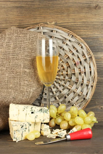 Composición de queso azul y una copa de vino con uvas sobre fondo de madera — Foto de Stock