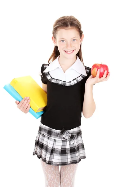 Hermosa niña en uniforme escolar con libros y manzana aislada en blanco —  Fotos de Stock