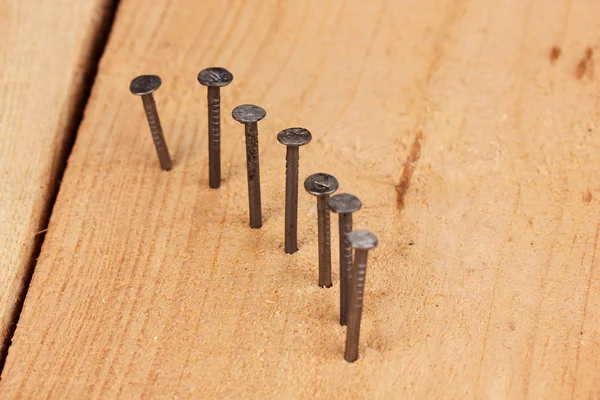 Pregos de metal em prancha de madeira — Fotografia de Stock