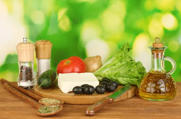 Ingredients for a Greek salad on green background close-up — Stock Photo, Image