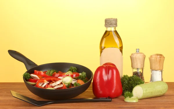 黄色の背景に野菜とフライパン — ストック写真