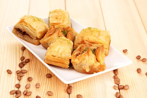 Baklava dulce en plato sobre fondo de madera —  Fotos de Stock