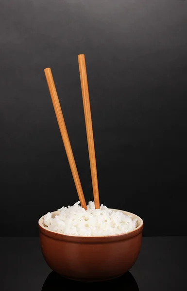 Tigela de arroz e pauzinhos sobre fundo cinzento — Fotografia de Stock