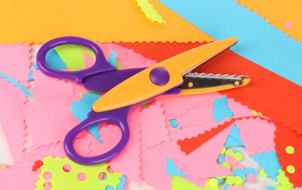 Цветные зигзагообразные ножницы на фоне цветной бумаги — стоковое фото