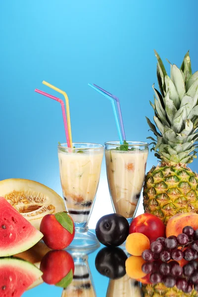 Milk shakes with fruit on blue background close-up — Stock Photo, Image