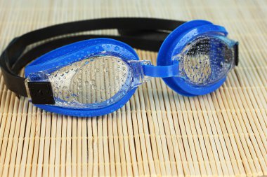 Mavi Yüzme gözlüğü ile bir bambu yastık üzerinde damla