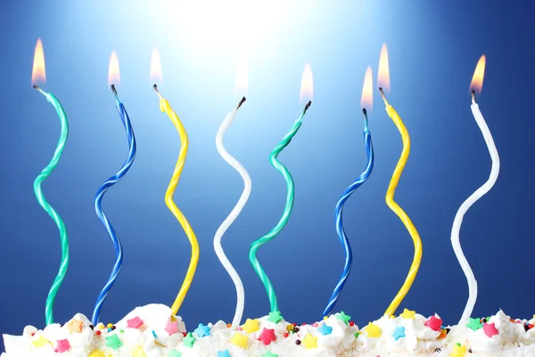 Schöne Geburtstagskerzen auf blauem Hintergrund — Stockfoto