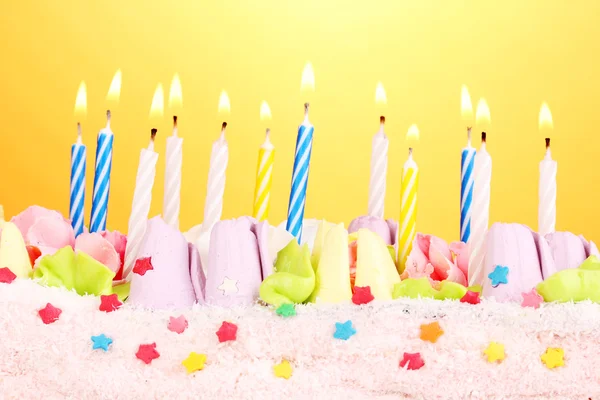 Birthday cake with candles on yellow background — Stock Photo, Image