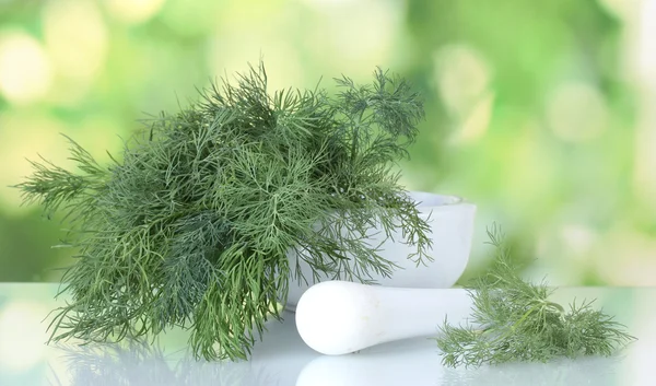 Укроп в растворе и пестик на зеленом фоне — стоковое фото