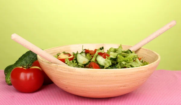 Čerstvý salát s rajčaty a okurkami na zeleném pozadí — Stock fotografie