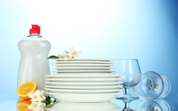 Boş temiz tabak ve bardak sıvı ve mavi zemin üzerine limon bulaşık yıkama ile — Stok fotoğraf
