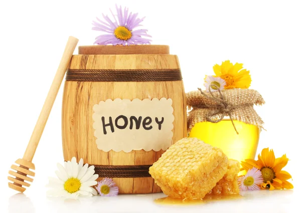 Zoete honing in kruik en vat met honingraat, houten drizzler en bloemen geïsoleerd op wit — Stockfoto