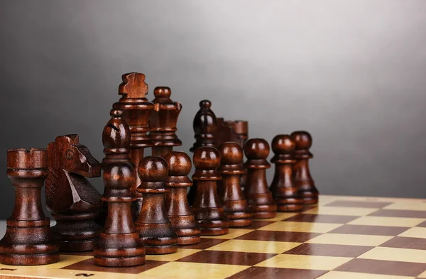 Schaakbord met schaakstukken op grijze achtergrond — Stockfoto