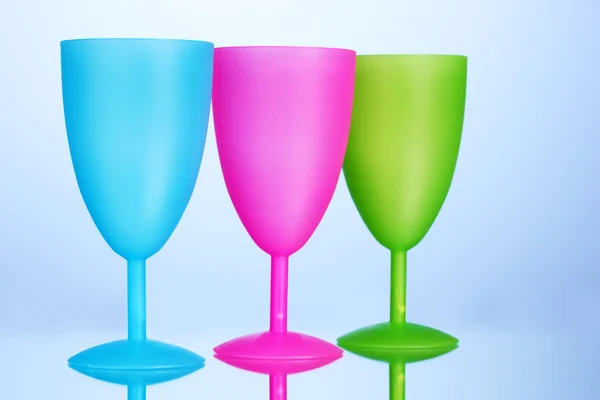 Bright plastic goblets on blue background — Stock Photo, Image