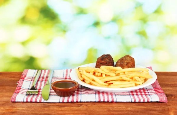 Potatoes fries with burgers on the plate on green background close-up — Stock Photo, Image