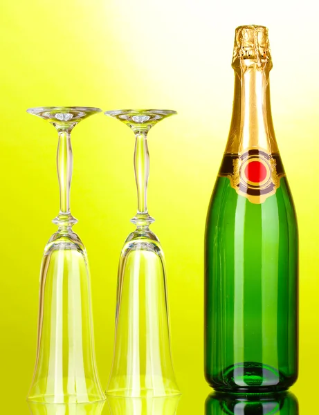 Butelka szampana i puchary na zielonym tle — Zdjęcie stockowe