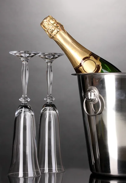 Botella de champán en cubo con hielo y vasos sobre fondo gris —  Fotos de Stock