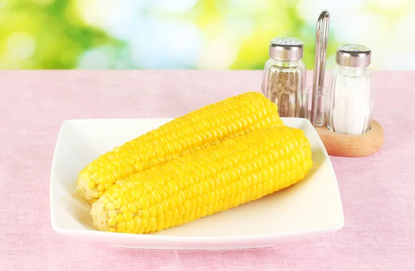 Boiled corn on the pink table cloths on the background of nature — Stock Photo, Image