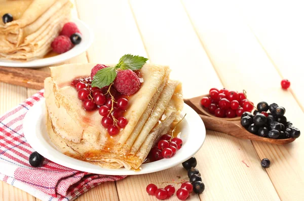 Вкусные блины с ягодами, джемом и медом на деревянном столе — стоковое фото