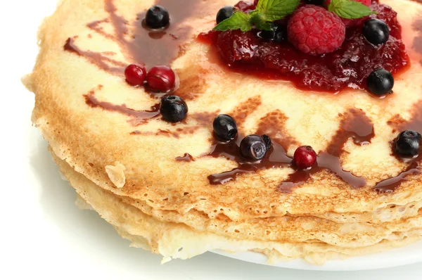 Leckere Pfannkuchen mit Beeren und Marmelade auf Teller isoliert auf weiß — Stockfoto