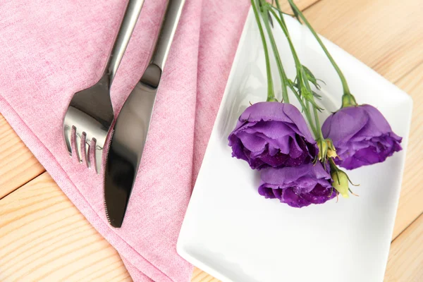 Посуда с цветами на яркой салфетке крупным планом — стоковое фото