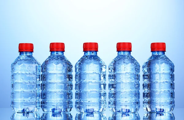 Műanyag palack víz a kék háttér — Stock Fotó
