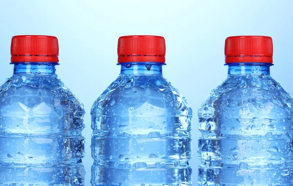 Bouteilles d'eau en plastique sur fond bleu — Photo