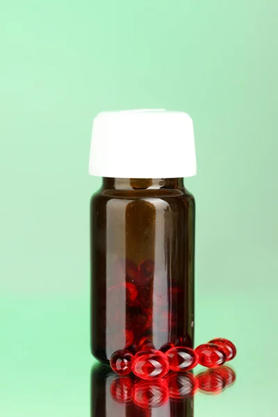 Jar of pills on green background close-up — Stock Photo, Image