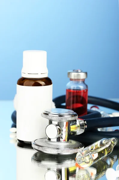 Medicijnen en een stethoscoop op een blauwe achtergrond close-up — Stockfoto